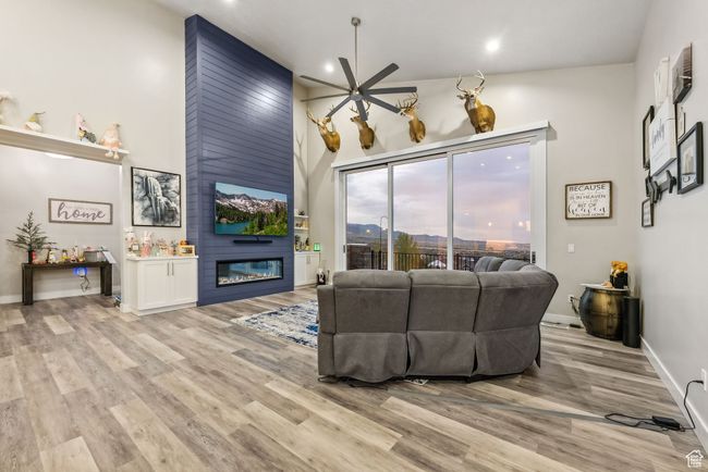 Living room featuring light wood finished floors, recessed lighting, ceiling fan, and a fireplace | Image 79