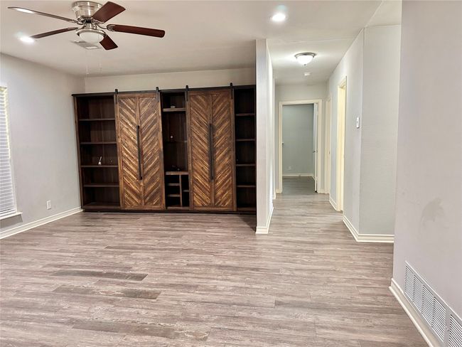 Spare room with ceiling fan, wood finished floors, and recessed lighting | Image 9