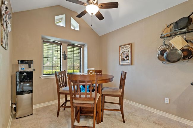 Dining room featuring lofted ceiling, a ceiling fan, baseboards, and light tile patterned floors | Image 19