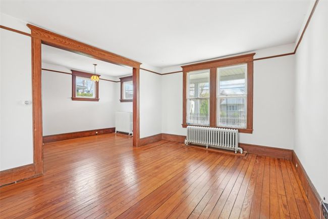 Unfurnished room with radiator, baseboards, and hardwood / wood-style flooring | Image 7