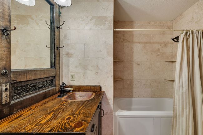 Bathroom with vanity, shower / bath combo, and a textured ceiling | Image 11
