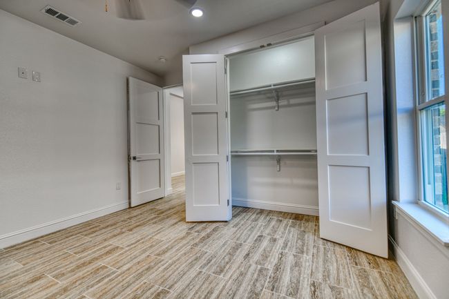 Unfurnished bedroom featuring a closet, light hardwood / wood-style flooring, and multiple windows | Image 35