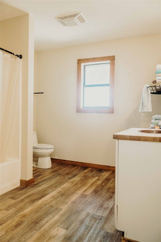 Bathroom with vanity, wood finished floors, and shower / tub combo | Image 25