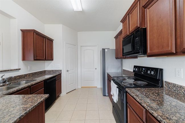 Kitchen features tile flooring and granite counter tops. | Image 11