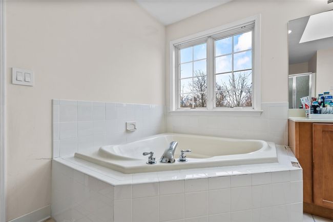 Full bathroom featuring a shower stall, a garden tub, and vanity | Image 25