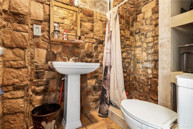 Full bathroom featuring a shower stall, toilet, and a sink | Image 16