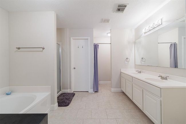 Primary bath with tile flooring garden tub and separate walk-in shower. | Image 18