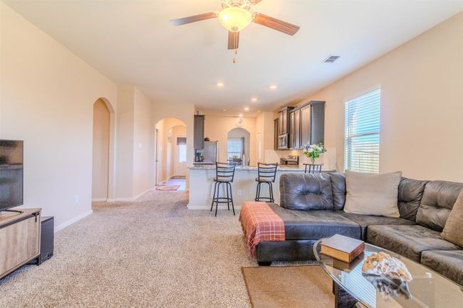 Carpeted living room with ceiling fan | Image 15