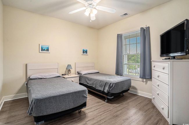 Bedroom with wood finished floors, baseboards, and a ceiling fan | Image 11