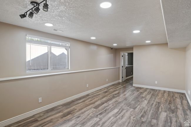 Below grade area featuring baseboards, recessed lighting, wood finished floors, and a textured ceiling | Image 26