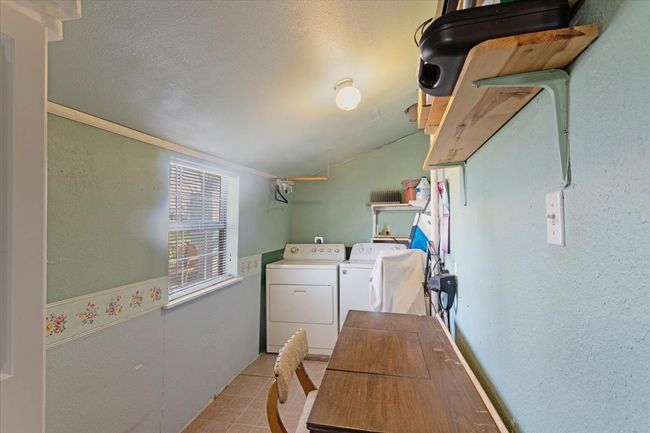 Clothes washing area featuring separate washer and dryer, a textured ceiling, and light tile patterned floors | Image 21