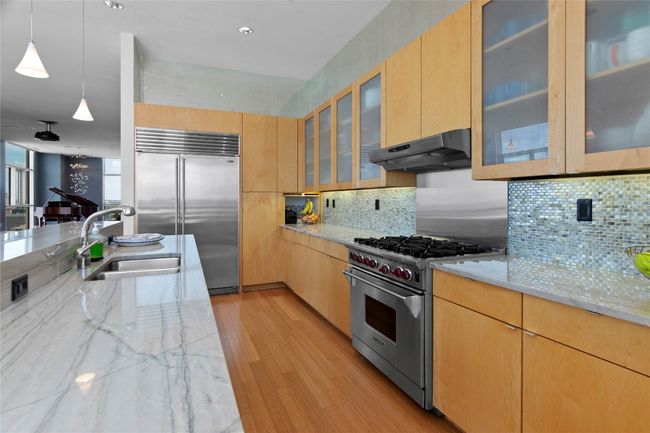 Gourmet kitchen with sleek countertops and ample storage. | Image 20