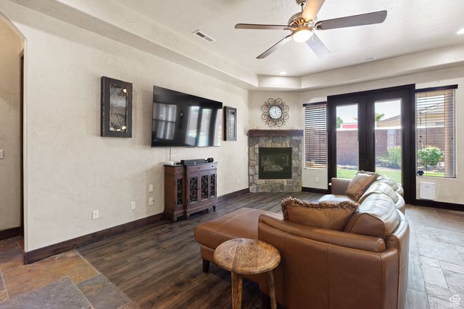 Living area with stone tile floors, a fireplace, a ceiling fan, recessed lighting, and arched walkways | Image 41
