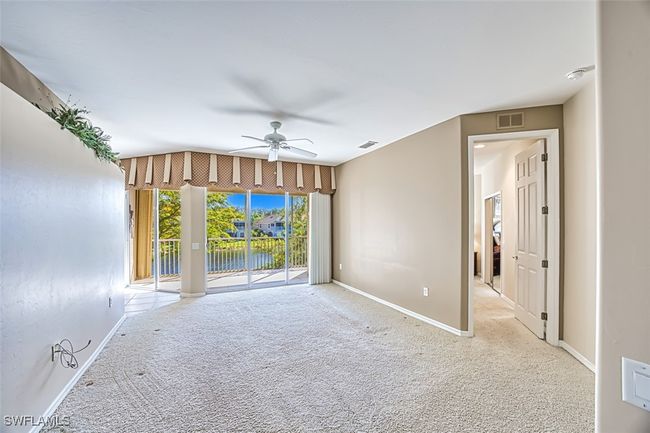 Unfurnished room featuring light carpet, ceiling fan, and lofted ceiling | Image 15