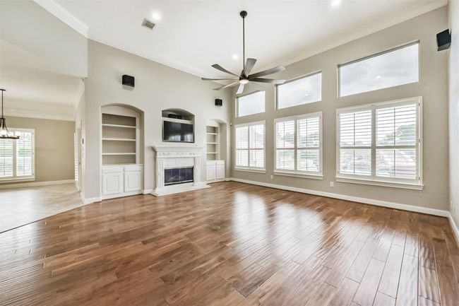 This is a true Great room. Tall ceiling, wall of windows, distressed wood floors and cozy fire place. | Image 4