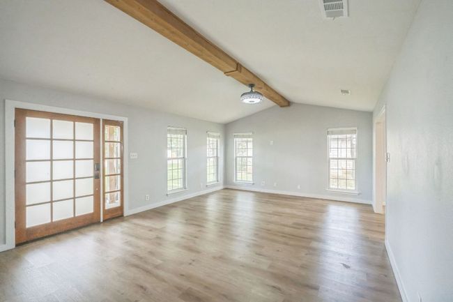 Living room with healthy amount of natural light and light wood flooring with large front door with window | Image 4