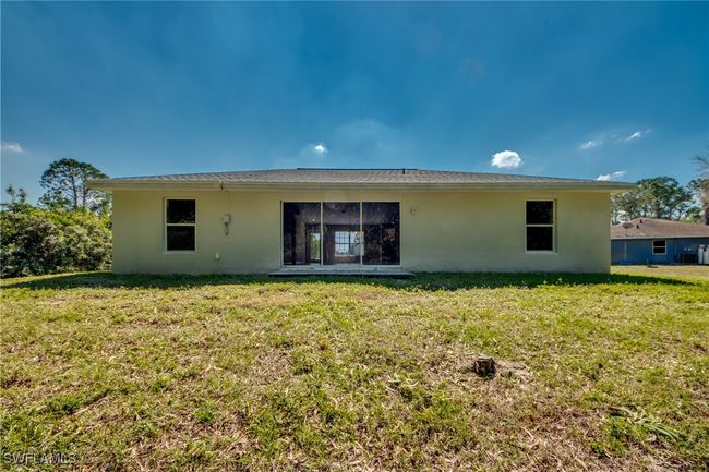 Rear view of property with a yard and stucco siding | Image 49