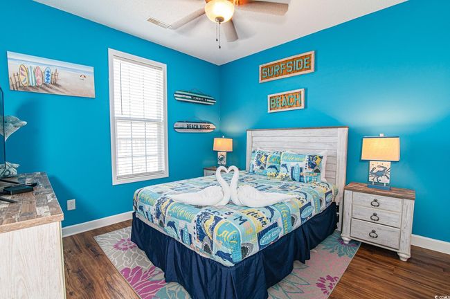 Bedroom featuring multiple windows, dark wood-type flooring, baseboards, and ceiling fan | Image 39