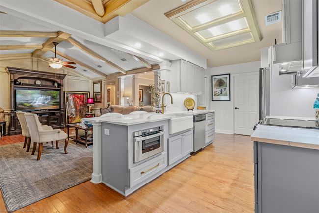 Recently renovated kitchen includes new cabinetry with under cabinet lighting, quartz counters, stainless appliances, breakfast level bar open to living area | Image 6