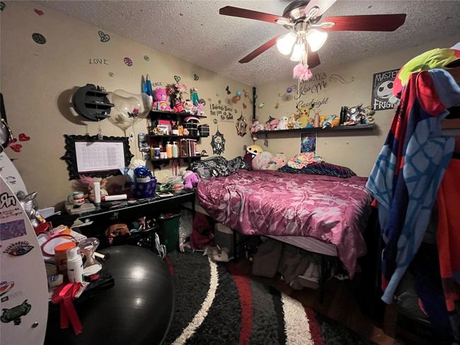 Bedroom featuring a textured ceiling and ceiling fan | Image 8