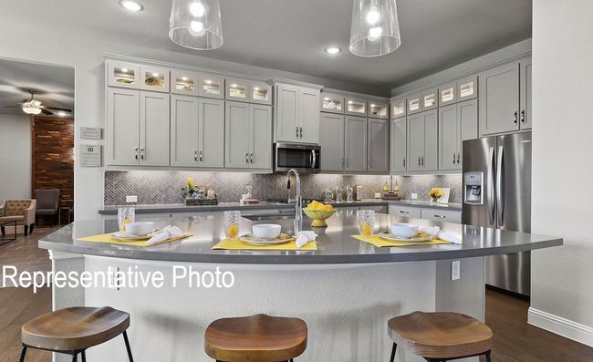 Kitchen featuring stainless steel appliances, a breakfast bar, backsplash, hanging light fixtures, and recessed lighting | Image 5