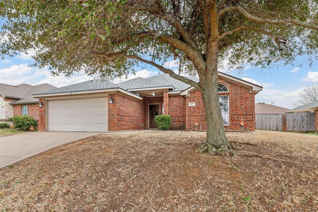 Single story home with brick siding, a shingled roof, fence, a garage, and driveway | Image 4