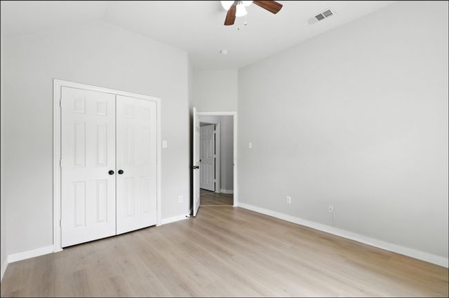 Unfurnished bedroom featuring light wood-style flooring, a closet, a ceiling fan, and vaulted ceiling | Image 12