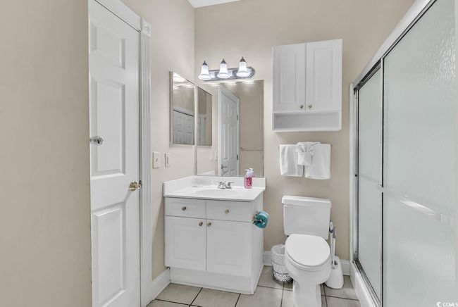 Bathroom featuring vanity, tile patterned flooring, toilet, a stall shower, and baseboards | Image 16