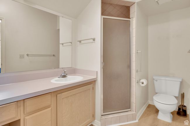 Full bath featuring toilet, vanity, a shower stall, baseboards, and wood finished floors | Image 16