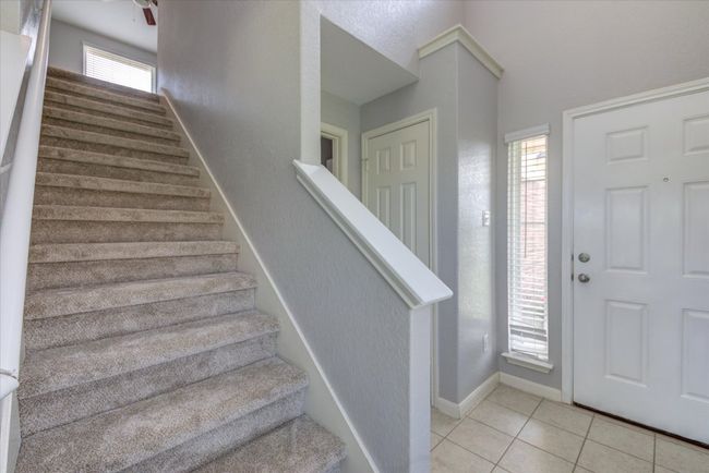 Foyer entrance and stairway with freshly installed carpet throughout upstairs. | Image 18