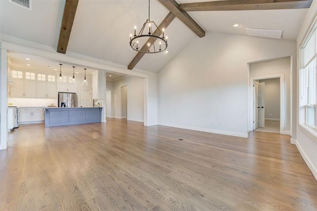 Living room with vaulted ceiling and accent beams. | Image 4
