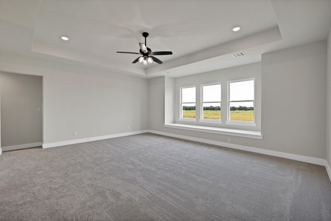 Empty room featuring a tray ceiling, carpet floors, a ceiling fan, and recessed lighting | Image 23