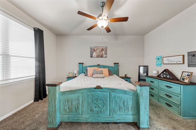 Bedroom with light colored carpet, baseboards, and a ceiling fan | Image 21