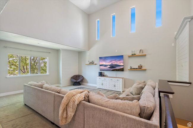 Living area featuring a towering ceiling and carpet flooring | Image 11
