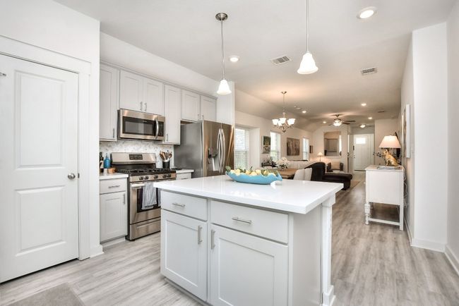 Kitchen featuring visible vents, light countertops, appliances with stainless steel finishes, and a center island | Image 15