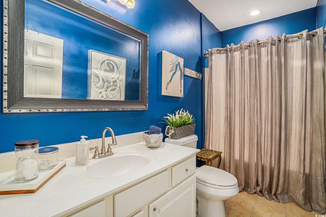 Bathroom with vanity, tile patterned floors, and a shower with shower curtain | Image 17
