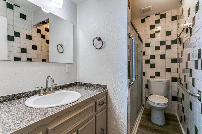 Full bathroom with toilet, visible vents, wood finished floors, a shower stall, and vanity | Image 24