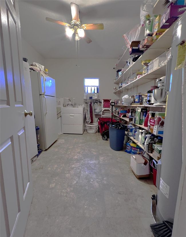 This utility room is large enough for the washer, dryer, freezer, and extra fridge. Oh, and shelving for extra pantry use or storage. | Image 27