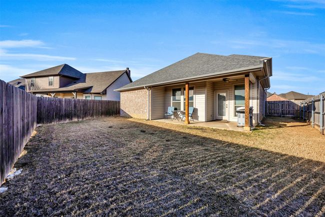 Back of house featuring central air condition unit, a lawn, a patio, a fenced backyard, and a shingled roof | Image 28