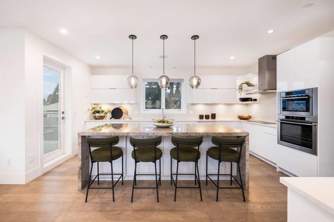Kitchen featuring modern cabinets, open shelves, double oven, white cabinets, and wall chimney range hood | Image 8