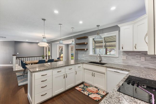 Kitchen with crown molding, tasteful backsplash, a peninsula, dishwasher, and a sink | Image 6