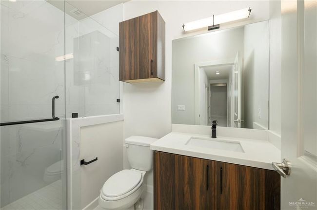 Bathroom featuring toilet, a marble finish shower, and vanity | Image 14