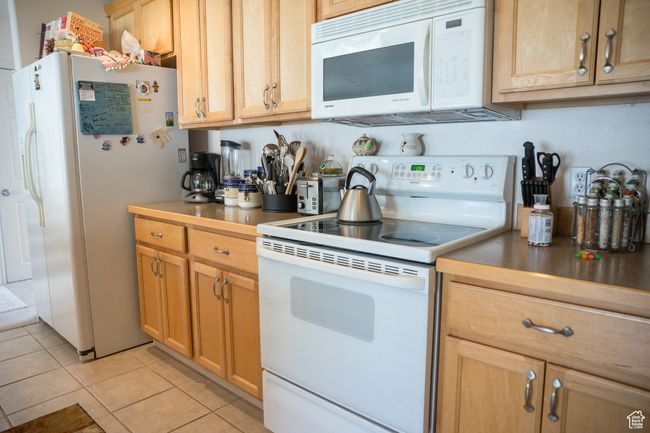 Kitchen featuring light tile patterned floors and white appliances | Image 9