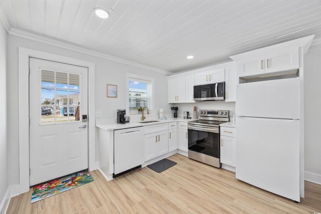 Kitchen featuring appliances with stainless steel finishes, a sink, recessed lighting, light wood-style flooring, and ornamental molding | Image 18