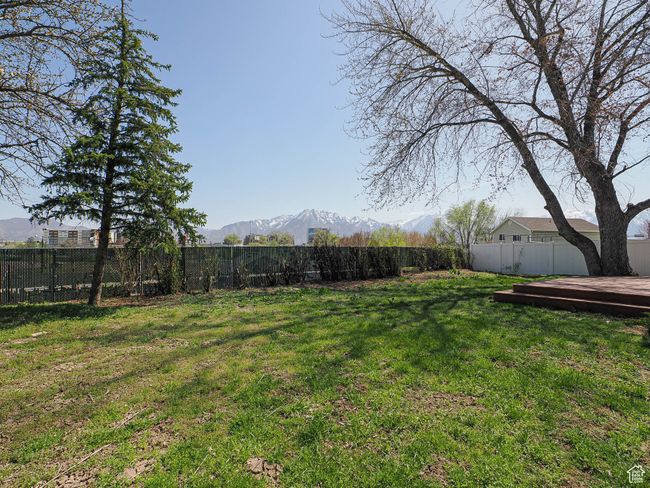 Fenced backyard featuring a deck with mountain view | Image 17