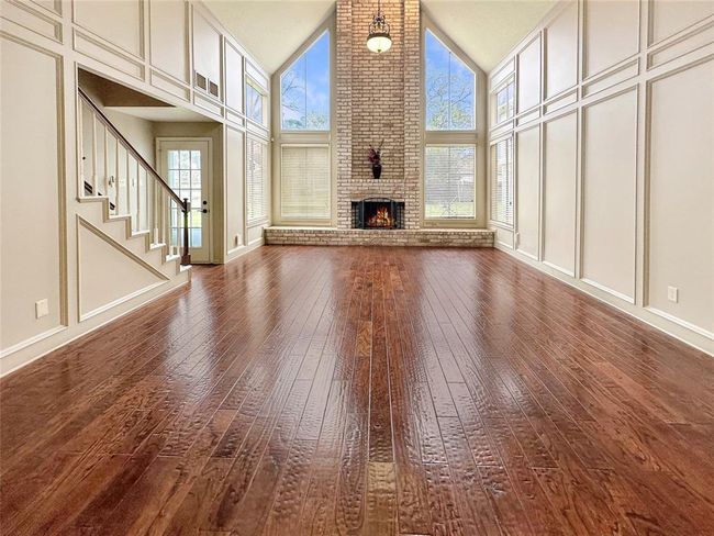 The living room is a statement of warmth and elegance, with rich wood flooring that adds both character and durability. | Image 5
