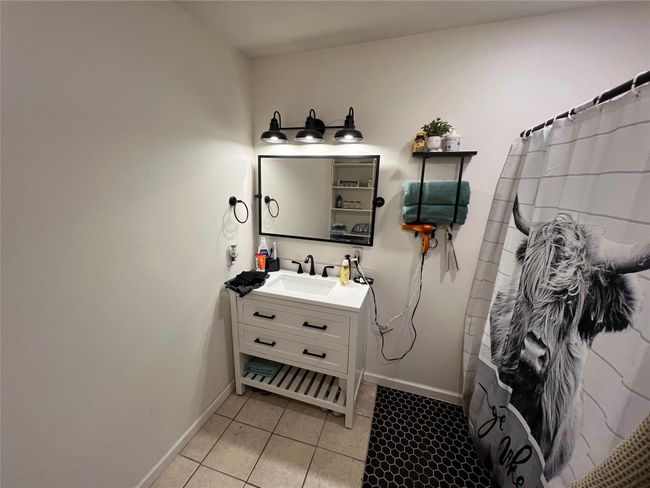 Full bath featuring vanity, baseboards, tile patterned flooring, and a shower with curtain | Image 20
