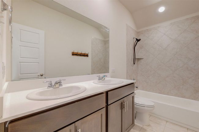 Bathroom featuring double vanity, bathing tub / shower combination, toilet, and a sink | Image 19