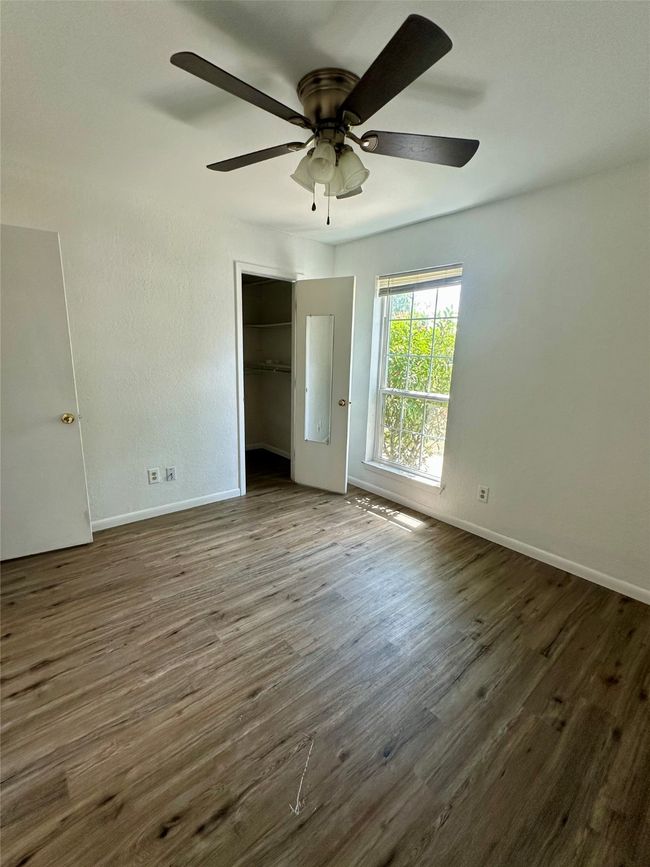 Unfurnished bedroom with wood finished floors, a closet, and a ceiling fan | Image 14