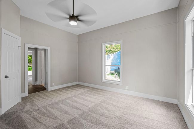 Unfurnished room featuring light colored carpet and a ceiling fan | Image 12